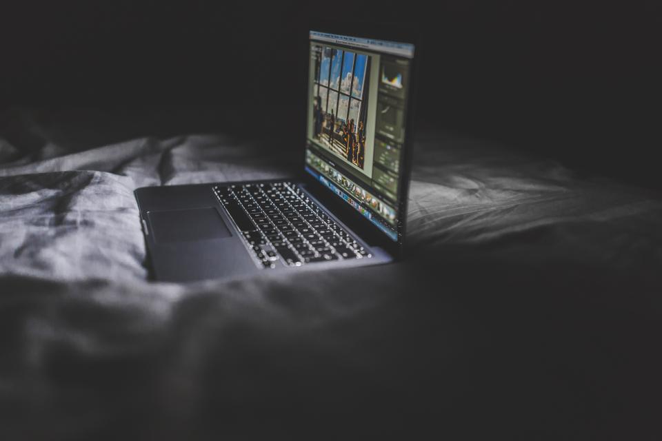 夜の部屋で開いたノートパソコン